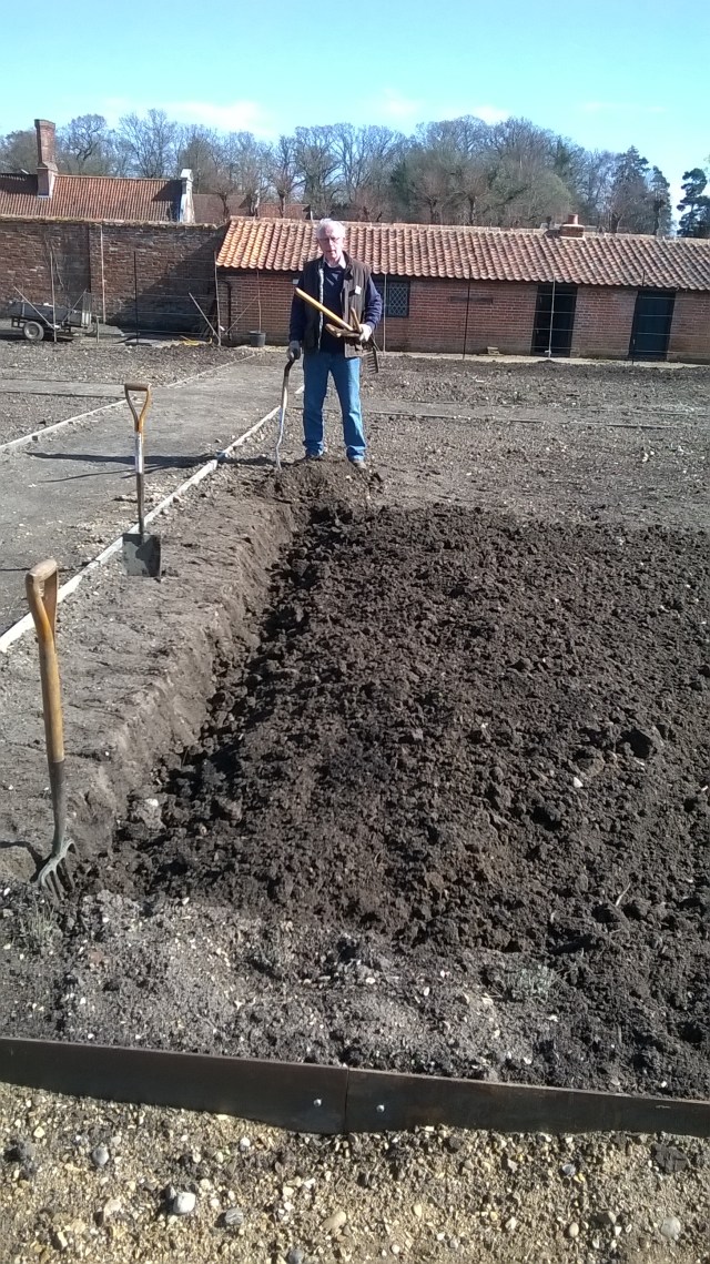 Norfolk Peter resting on his spade after a hard day's digging